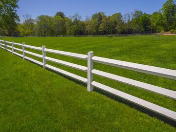 white farm fence in the grass